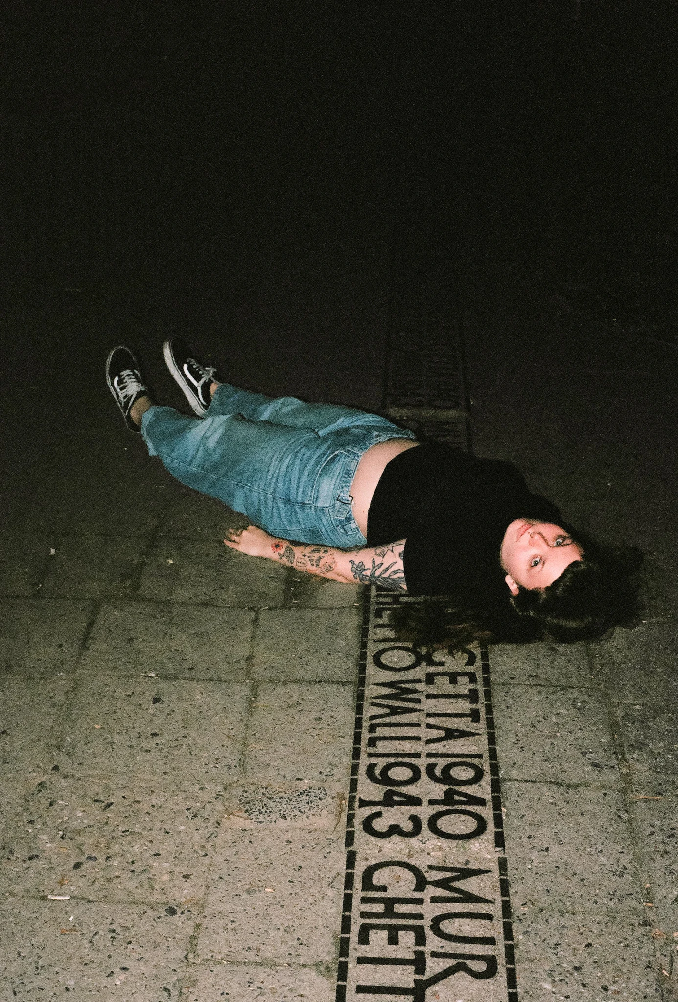 A person lying on pavement at night